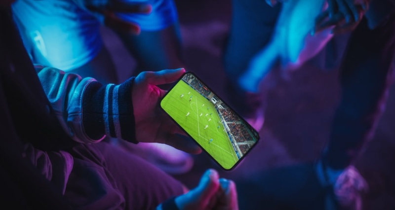 نمایش شرطبندی زنده ورزشی روی موبایل در حال تماشای مسابقه فوتبال بهصورت لحظهای